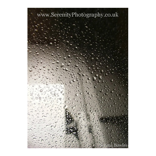 Abstract image: water droplets on the window; snow outside